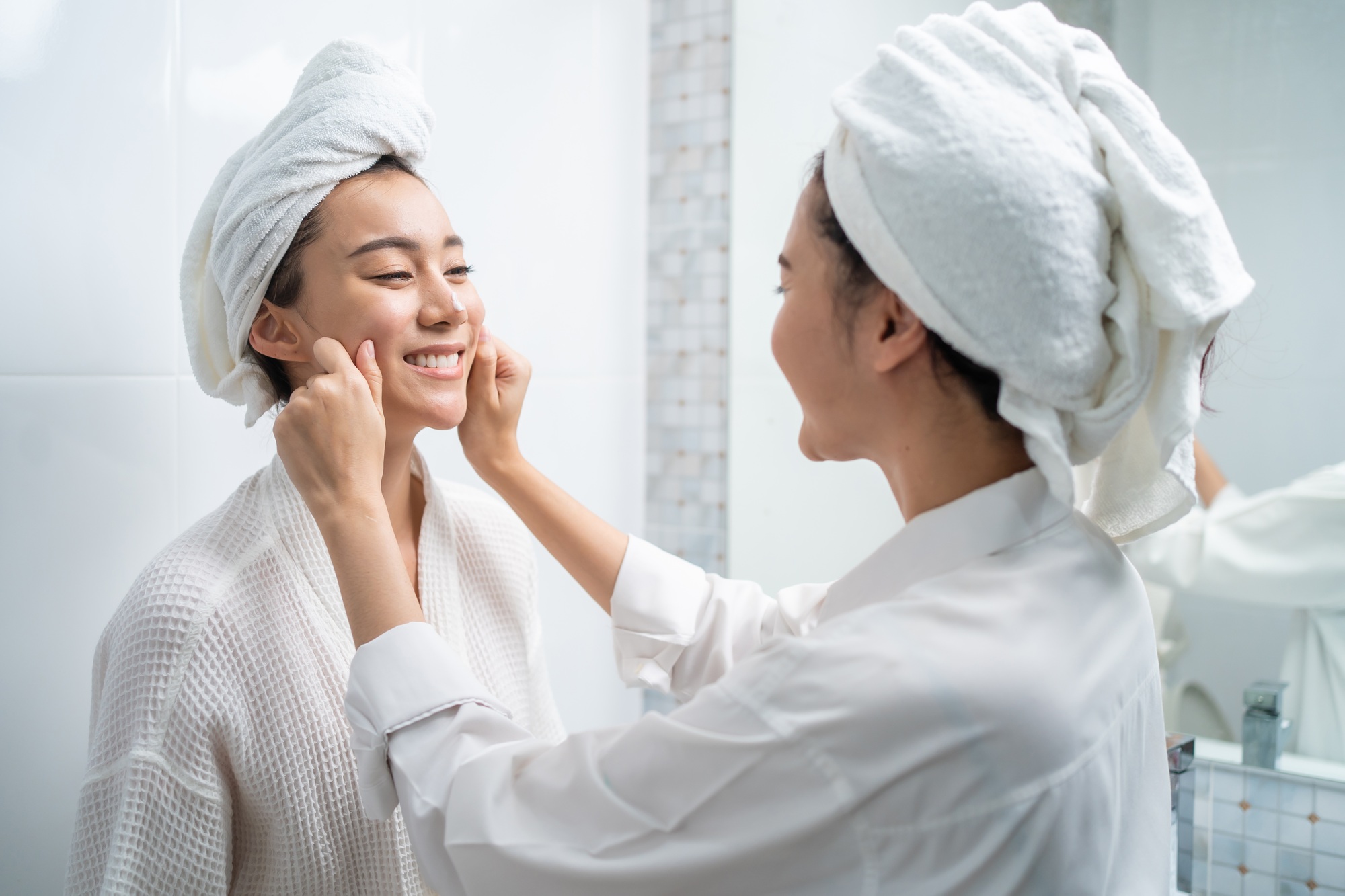 Asian lesbian gay couple putting smooth and skin care for facial soft. Beauty, skin care and health